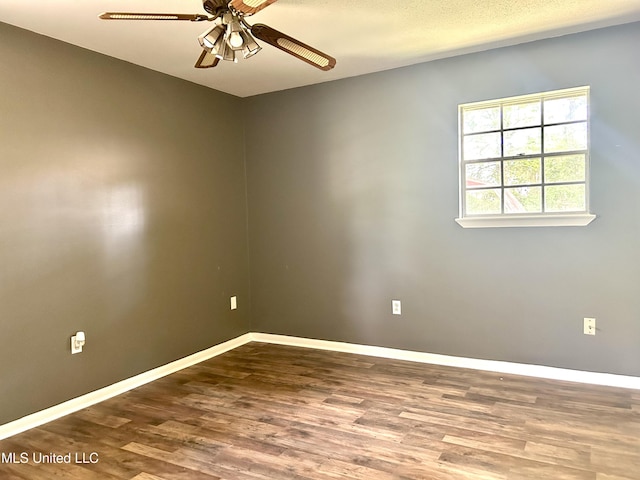 empty room with baseboards, ceiling fan, and wood finished floors