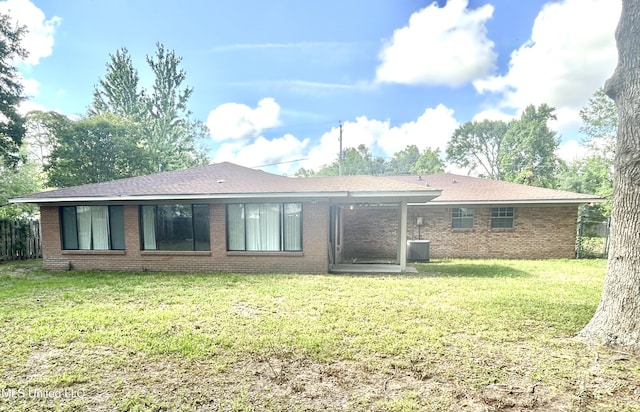 back of house featuring a yard and brick siding