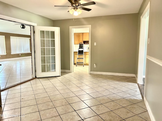 unfurnished room with light tile patterned flooring, a ceiling fan, ornamental molding, and baseboards