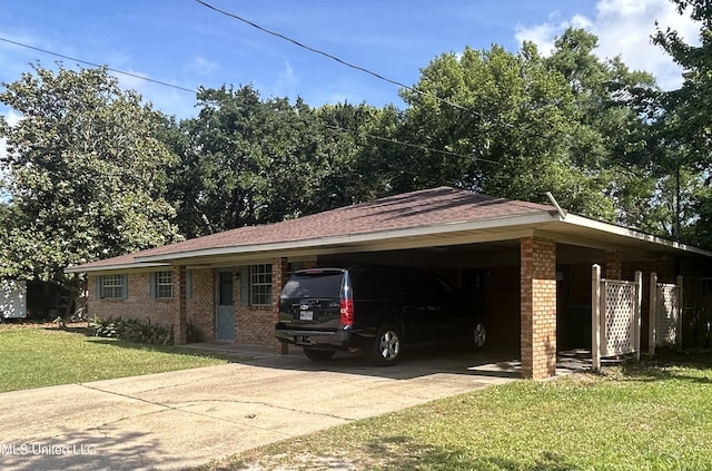 view of front of house with an attached carport, driveway, a front lawn, and brick siding