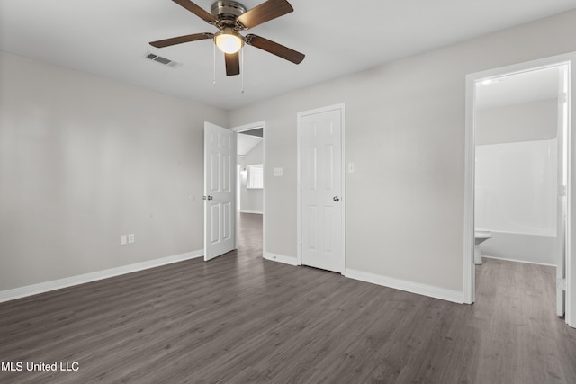 unfurnished bedroom with ensuite bath, dark hardwood / wood-style floors, and ceiling fan