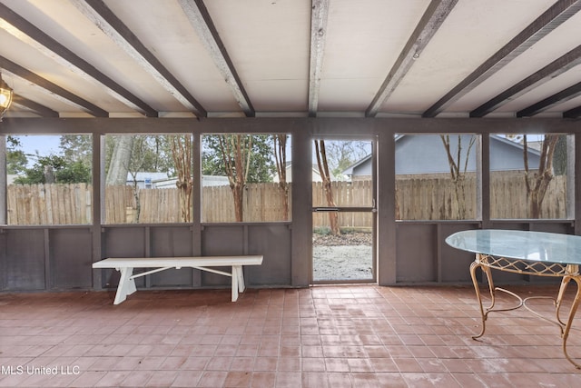 unfurnished sunroom with beamed ceiling