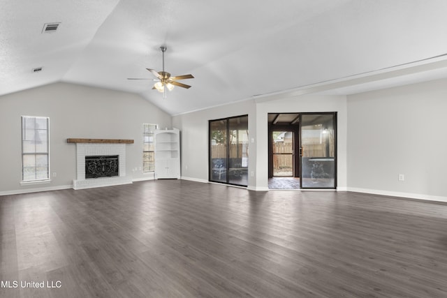 unfurnished living room with a brick fireplace, plenty of natural light, dark hardwood / wood-style floors, and ceiling fan