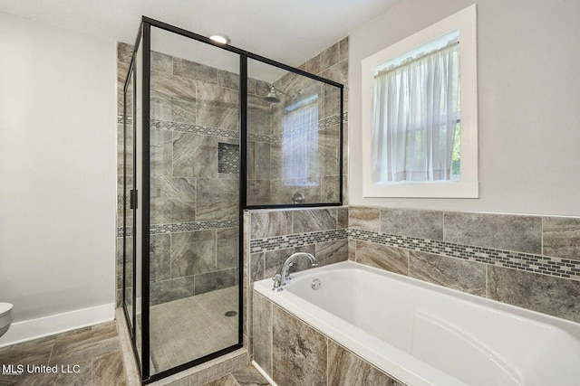 18153 Doc Lizana Rd, Gulfport, MS 39503 - bathroom with toilet, a garden tub, a shower stall, and baseboards