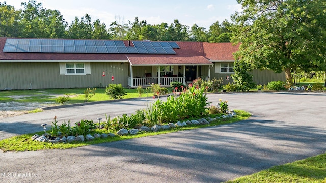 18153 Doc Lizana Rd, Gulfport, MS 39503 - ranch-style home featuring a porch, roof mounted solar panels, and driveway