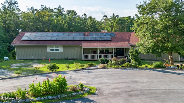 18153 Doc Lizana Rd, Gulfport, MS 39503 - ranch-style home featuring a porch, a front lawn, and roof mounted solar panels