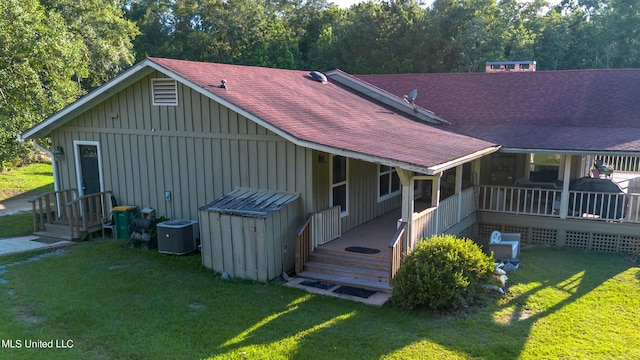 18153 Doc Lizana Rd, Gulfport, MS 39503 - back of house featuring a lawn, board and batten siding, central AC unit, and a shingled roof