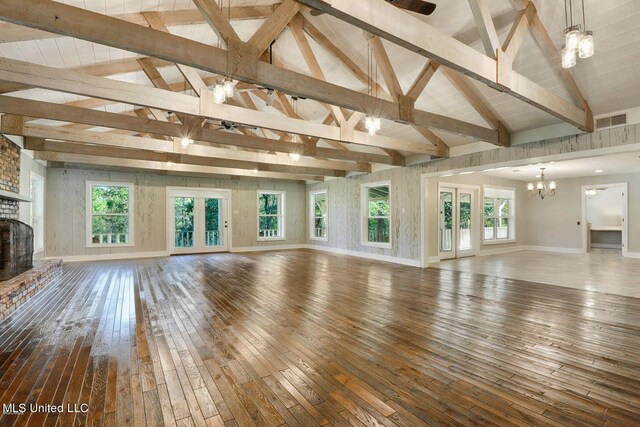 18153 Doc Lizana Rd, Gulfport, MS 39503 - unfurnished living room featuring hardwood / wood-style flooring, visible vents, baseboards, a brick fireplace, and vaulted ceiling with beams