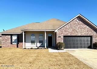 ranch-style home with a garage, concrete driveway, brick siding, and a front lawn