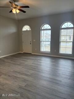 foyer with a ceiling fan, baseboards, and wood finished floors