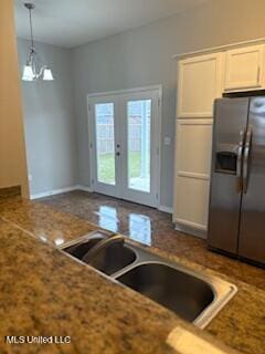 kitchen with pendant lighting, french doors, white cabinetry, a sink, and stainless steel fridge with ice dispenser