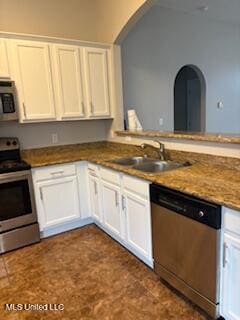 kitchen with arched walkways, white cabinets, appliances with stainless steel finishes, a peninsula, and a sink