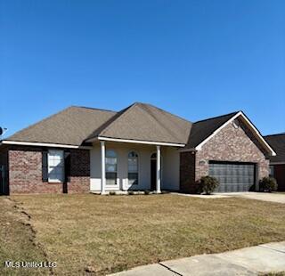 ranch-style home with a front yard, concrete driveway, brick siding, and an attached garage