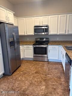 kitchen featuring stainless steel appliances and white cabinetry