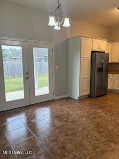 kitchen featuring hanging light fixtures, french doors, plenty of natural light, and refrigerator with ice dispenser