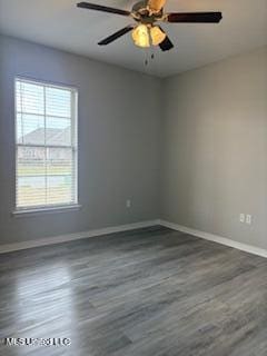 spare room with ceiling fan, wood finished floors, and baseboards