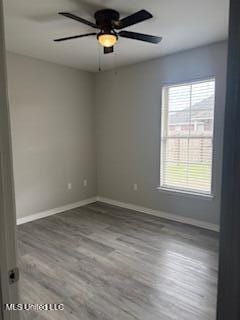 unfurnished room with a ceiling fan, baseboards, and wood finished floors