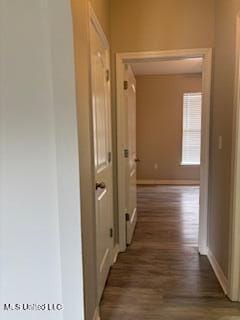 hall featuring baseboards and wood finished floors