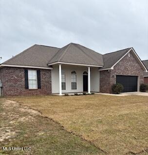 ranch-style home featuring a garage, a front lawn, and brick siding