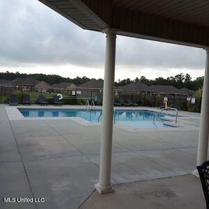 community pool with a patio and fence