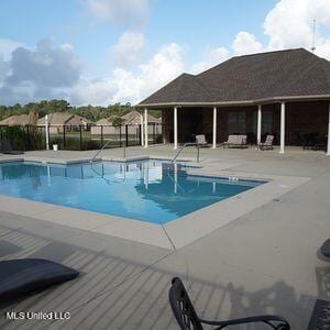 community pool featuring fence and a patio