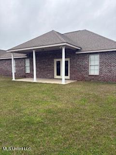 back of property with a patio and a yard