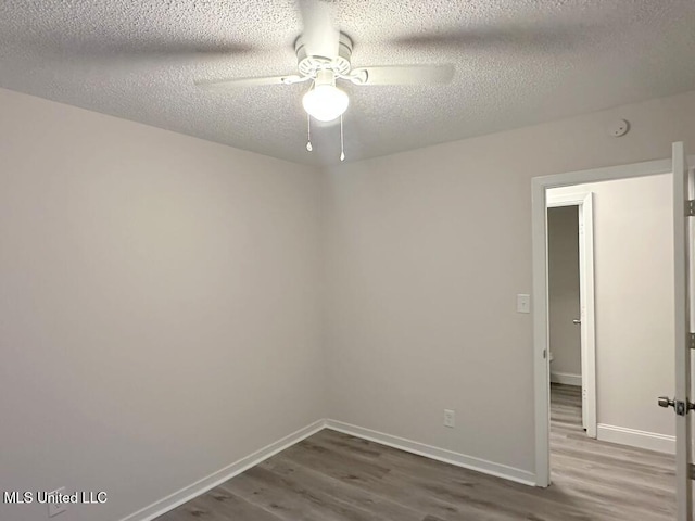 spare room featuring ceiling fan, a textured ceiling, and hardwood / wood-style flooring