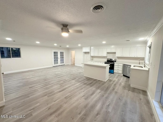 kitchen featuring sink, light hardwood / wood-style flooring, a textured ceiling, white cabinetry, and stainless steel appliances