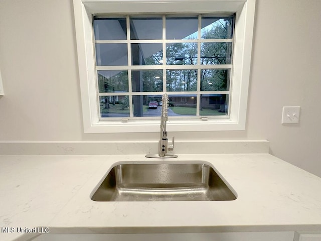 details with light stone countertops and sink