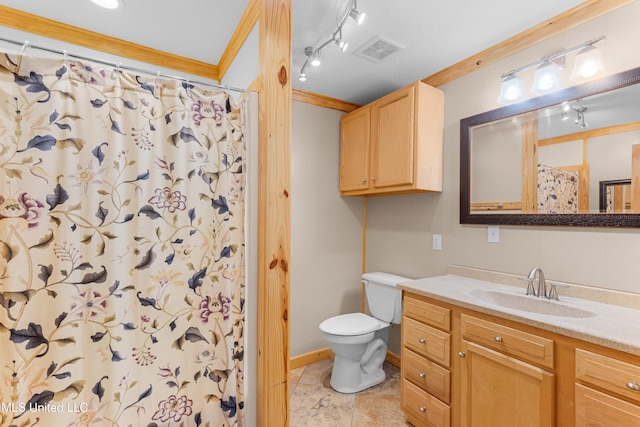 bathroom with vanity, toilet, crown molding, and rail lighting