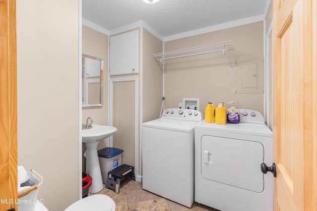 washroom featuring a textured ceiling, separate washer and dryer, and light tile patterned floors