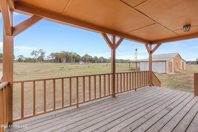 wooden terrace with a rural view, a shed, and a lawn