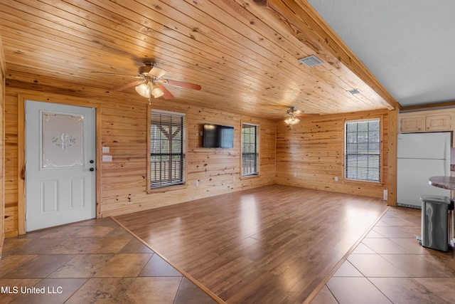 unfurnished living room featuring a wealth of natural light, hardwood / wood-style flooring, and ceiling fan