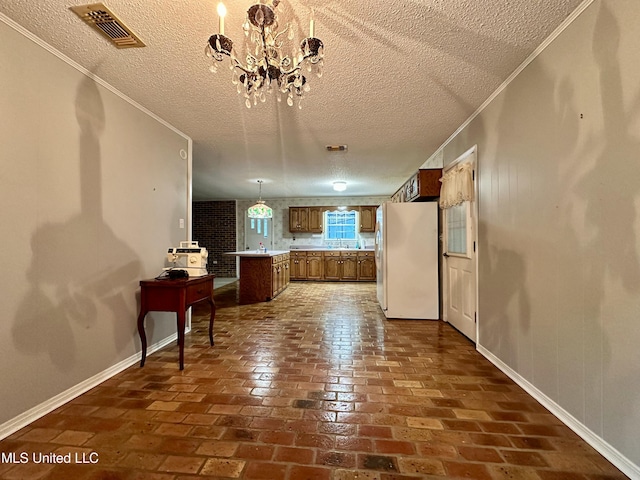 3427 Jr Davis Rd, Moss Point, MS 39562 - kitchen with brown cabinets, freestanding refrigerator, a textured ceiling, visible vents, and brick floor