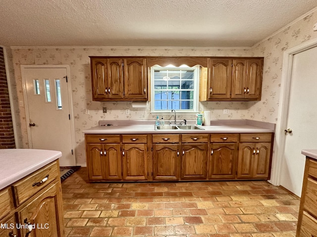 3427 Jr Davis Rd, Moss Point, MS 39562 - kitchen featuring wallpapered walls, a textured ceiling, brown cabinets, and a sink