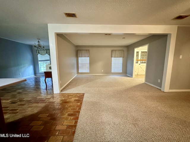 3427 Jr Davis Rd, Moss Point, MS 39562 - empty room with baseboards, a notable chandelier, carpet flooring, and visible vents