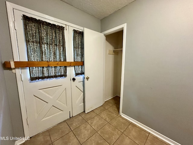 3427 Jr Davis Rd, Moss Point, MS 39562 - doorway to outside with tile patterned flooring, a textured ceiling, and baseboards