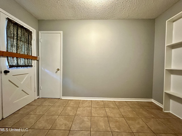 3427 Jr Davis Rd, Moss Point, MS 39562 - interior space with tile patterned floors, a textured ceiling, built in features, and baseboards