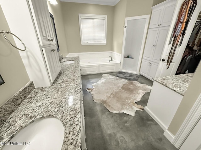 bathroom featuring a spacious closet, vanity, and a bath