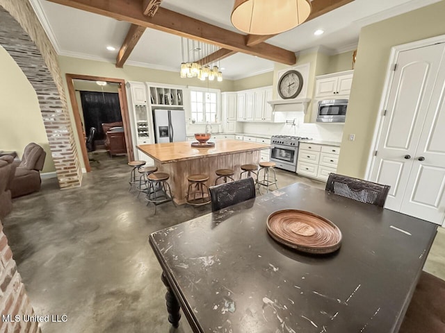 dining room with ornamental molding, beamed ceiling, recessed lighting, and finished concrete floors