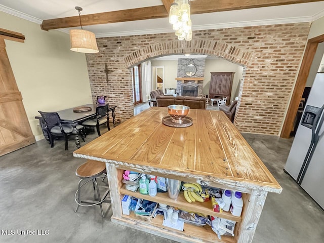 dining area with arched walkways, brick wall, and finished concrete floors