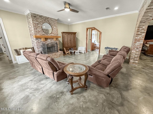 living area with visible vents, ceiling fan, ornamental molding, a brick fireplace, and concrete floors