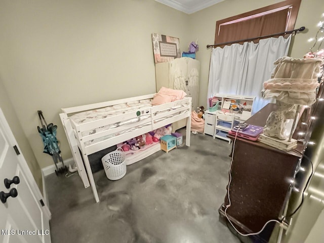 bedroom with ornamental molding, concrete floors, and baseboards