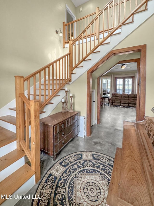 stairs featuring concrete floors and a high ceiling