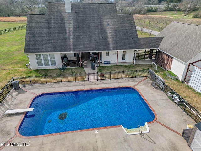 view of pool with a lawn, a fenced in pool, fence, a patio area, and a diving board