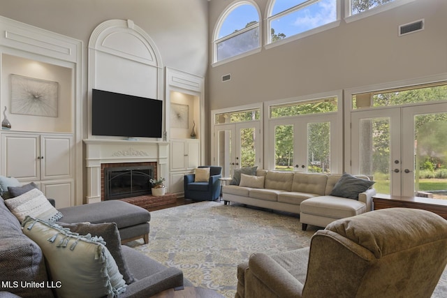 340 Sherborne Pl, Flowood, MS 39232 - living area featuring french doors, a high ceiling, a brick fireplace, and wood finished floors
