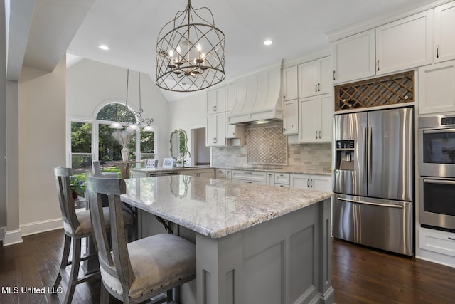 340 Sherborne Pl, Flowood, MS 39232 - kitchen featuring appliances with stainless steel finishes, a chandelier, a peninsula, light stone counters, and tasteful backsplash