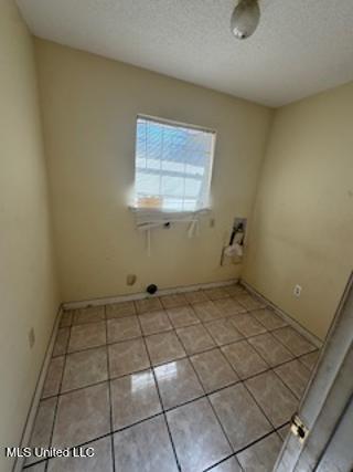 washroom featuring light tile patterned floors and a textured ceiling