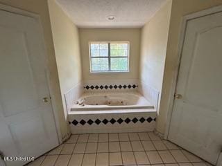 bathroom featuring tile patterned flooring and tiled bath