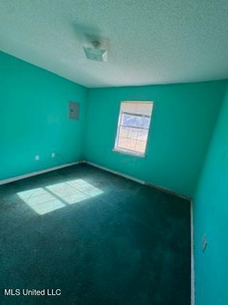 carpeted empty room featuring a textured ceiling